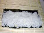Plasser nori-arket (tørket sjøgress) på rullematten. Spre ris jevnt over arket.